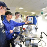 young_apprentices_in_technical_vocational_training_are_taught_by_older_trainers_on_a_cnc_lathes_machine